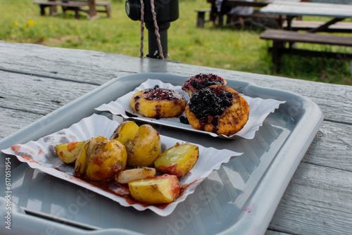 Fried potatoes and cheese dessert with fruits during an outdoor picnic.