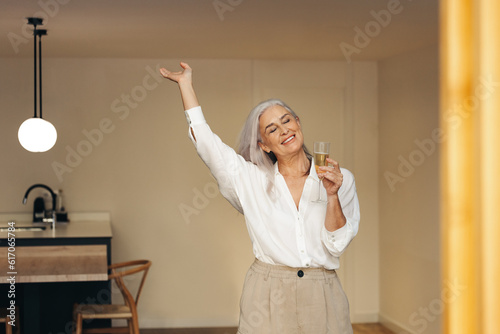 Senior woman celebrating her retirement with sparkling wine photo