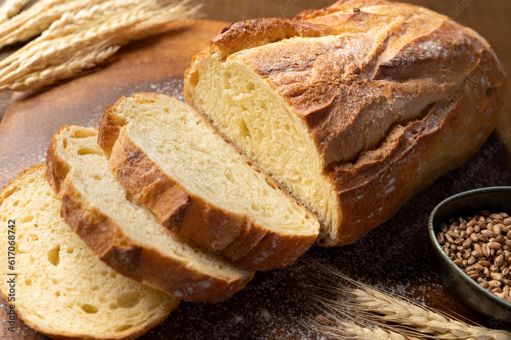Bakery - Freshly sliced bread. Freshly baked bread on rustic wooden background.