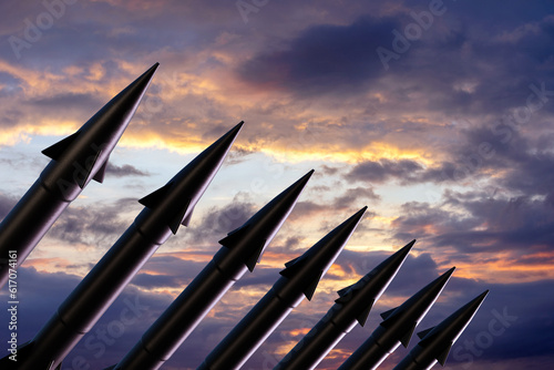 Row of nuclear ballistic missiles in silhouette ready to be launched at sunset. Illustration of the concept of nuclear wars and World War III