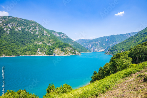 Landscape view of big lake between mountains at summer day. Travel background image with Piva lake in Montenegro