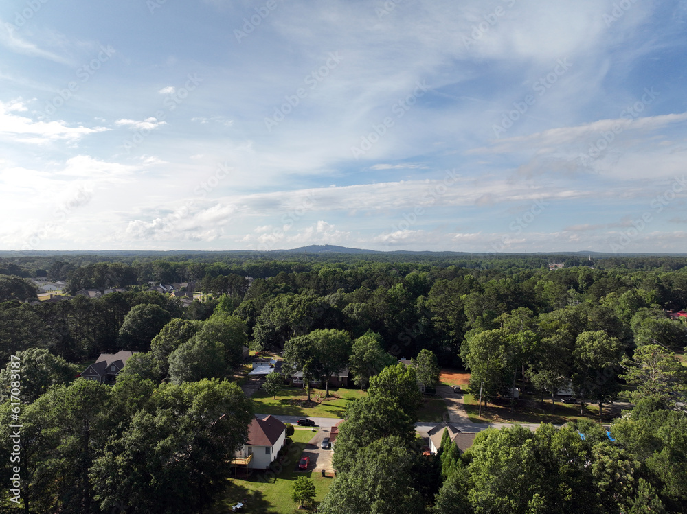 Drone photo of Powder Springs Georgia with white storm clouds. Over tree neighborhoods. Light from sunset. High vantage of Macland Rd. in high quality Birds year view.