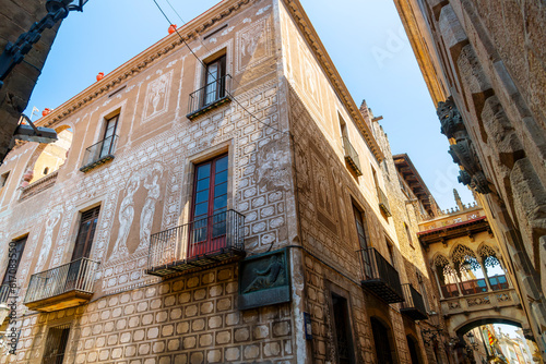 A beautiful historic Catalonian building alongside the Pont del Bisbe Bridge of Sighs and House of Canons in the narrow streets of the Gothic Quarter in Barcelona Spain.