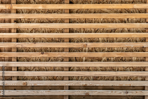Wooden background with planks in the form of a decorative lattice.