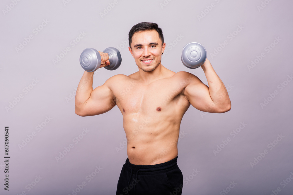 Shirtless bodybuilder showing his great body and holding dumbell. Shirtless bodybuilder showing his great body and holding dumbell.