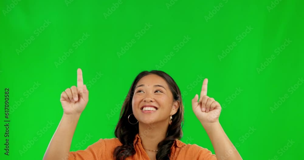 Happy asian woman, pointing and advertising on green screen against a studio background. Female person finger point for advertisement, sale discount or deal in notification, alert or news on mockup