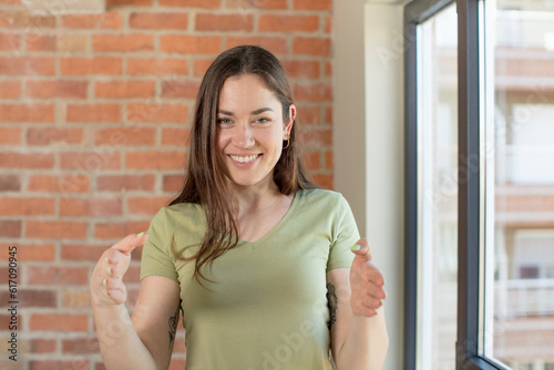 Free Download young adult pretty woman holding an object with both hands on copy space, showing, offering or advertising an object - GFXLoad