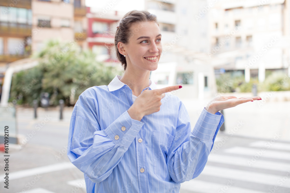 pretty woman smiling, feeling happy, carefree and satisfied, pointing to concept or idea on copy space on the side pretty woman smiling, feeling happy, carefree and satisfied, pointing to concept or idea on copy space on the side