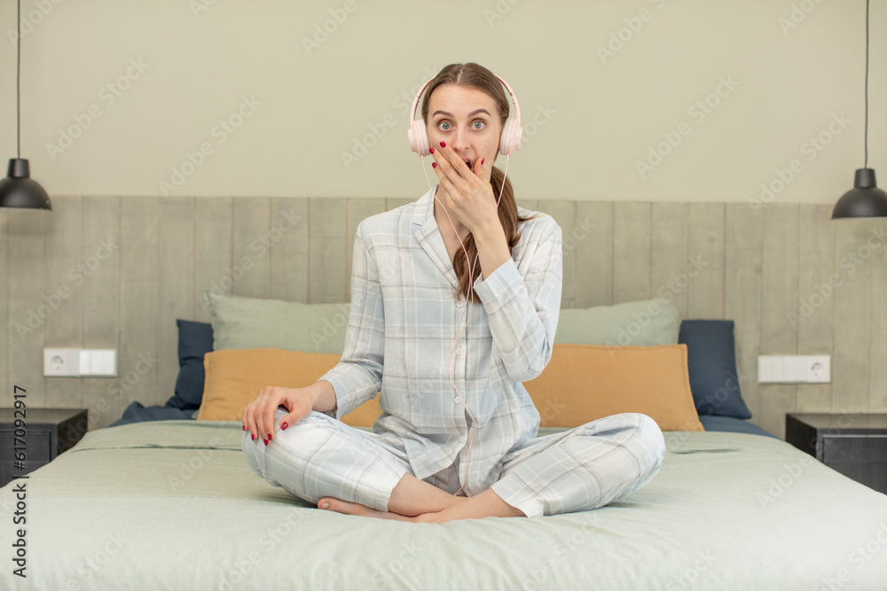 covering mouth with a hand and shocked or surprised expression. bed time concept covering mouth with a hand and shocked or surprised expression. bed time concept