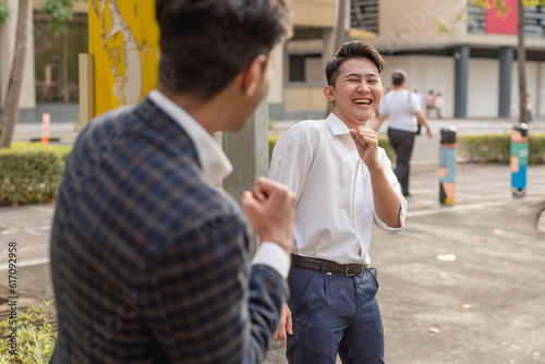 Two workmates make playful boxing stances while bonding each other, clowning around. A good and solid friendship.