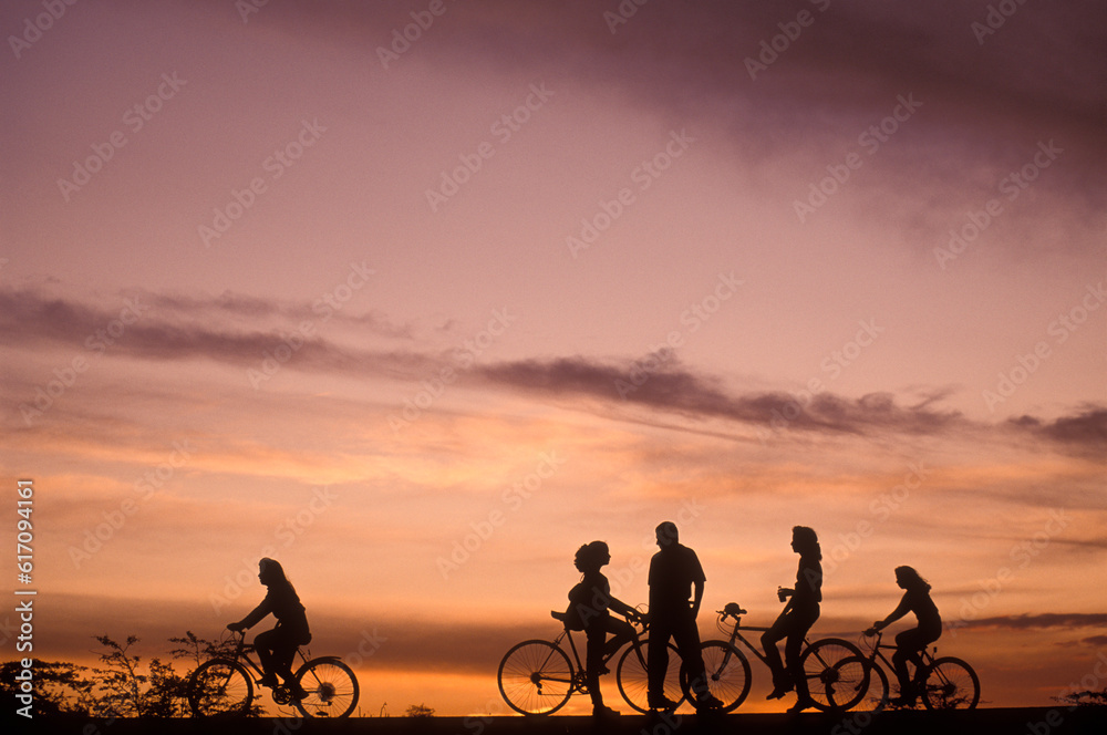 Young people in bicycles at sunset Young people in bicycles at sunset