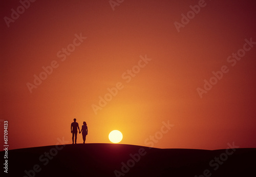 Couple walking towards the sun at sunset