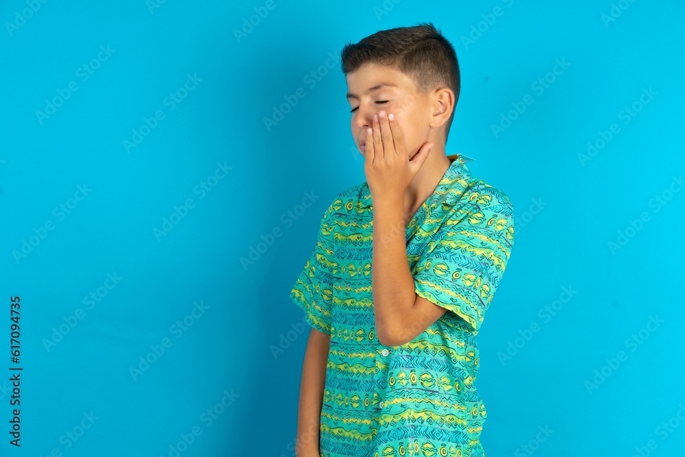 Little hispanic boy wearing green aztec shirt with toothache Little hispanic boy wearing green aztec shirt with toothache