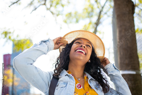 Fashionable young african american woman with hat smiling outside © mimagephotos