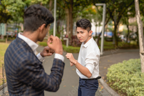 Two workmates make boxing stances or a light spar outside the park area. © Mdv Edwards