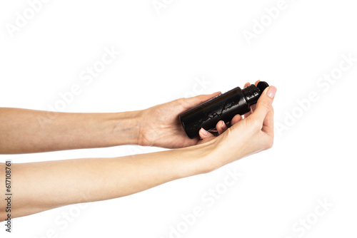 Black cosmetic flip top bottle in female hands isolated on white background.