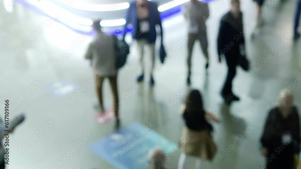 People walking down a corridor in a large room People walking down a corridor in a large room