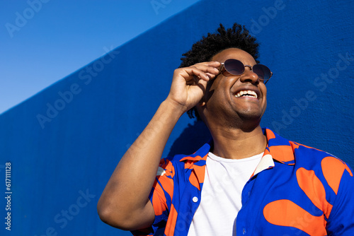 Cheerful ethnic man in trendy sunglasses