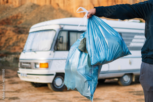 Crop traveler with plastic trash bag by camper van