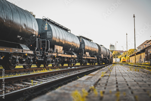 Transportation tank cars with oil during sunset. Railway containers. Freight railway wagons. Railway tank.