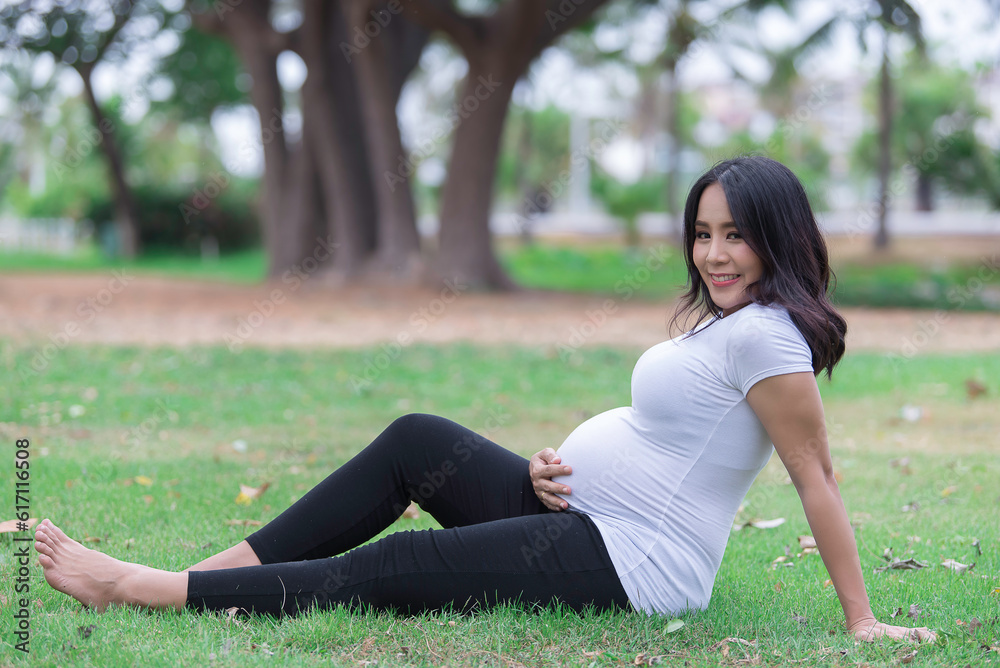 Portrait of asian Beautiful pregnant woman at the park,Thailand people,Happy woman concept,Her use hand touch her belly,Mother day concept Portrait of asian Beautiful pregnant woman at the park,Thailand people,Happy woman concept,Her use hand touch her belly,Mother day concept