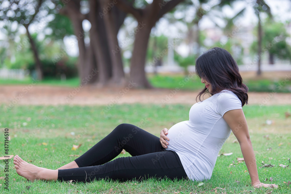 Portrait of asian Beautiful pregnant woman at the park,Thailand people,Happy woman concept,Her use hand touch her belly,Mother day concept Portrait of asian Beautiful pregnant woman at the park,Thailand people,Happy woman concept,Her use hand touch her belly,Mother day concept