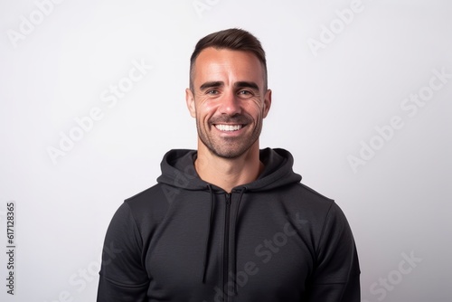 Handsome young man in black hoodie smiling and looking at camera. photo