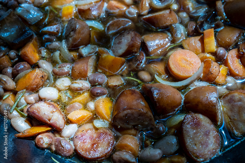 Fototapeta Naklejka Na Ścianę i Meble -  beans and sausage are cooked in a large cast iron pot