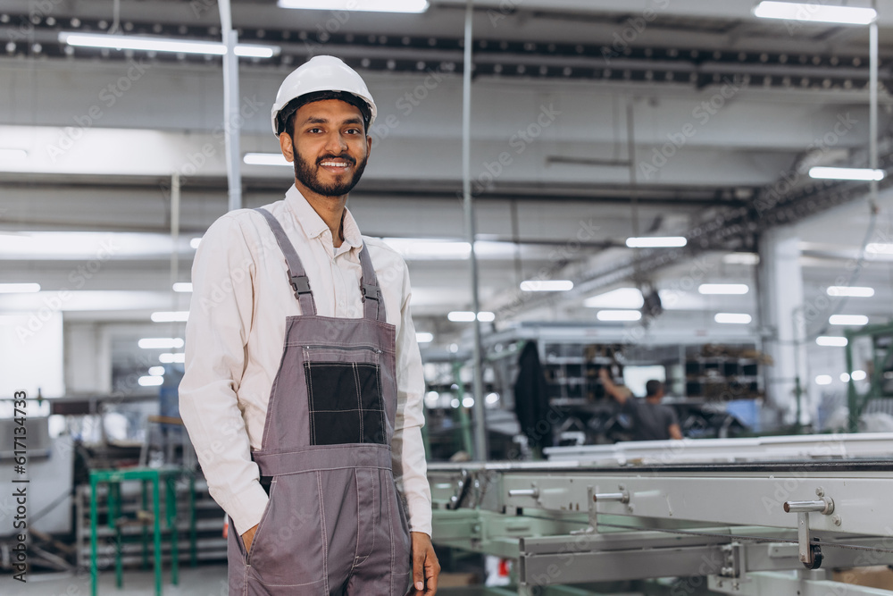 Operator of machine. Industrial Indian international worker indoors in factory. Young technician in white hard hat. Operator of machine. Industrial Indian international worker indoors in factory. Young technician in white hard hat.