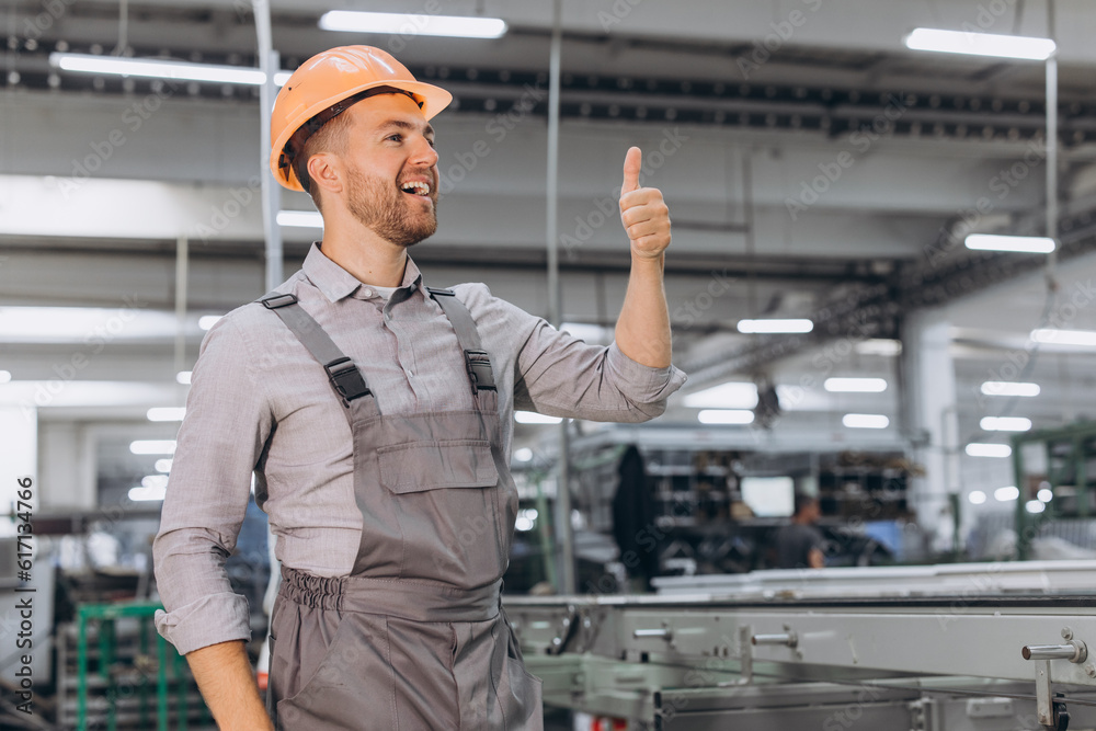 Operator of machine. Industrial worker indoors in factory. Young technician in orange hard hat. Operator of machine. Industrial worker indoors in factory. Young technician in orange hard hat.