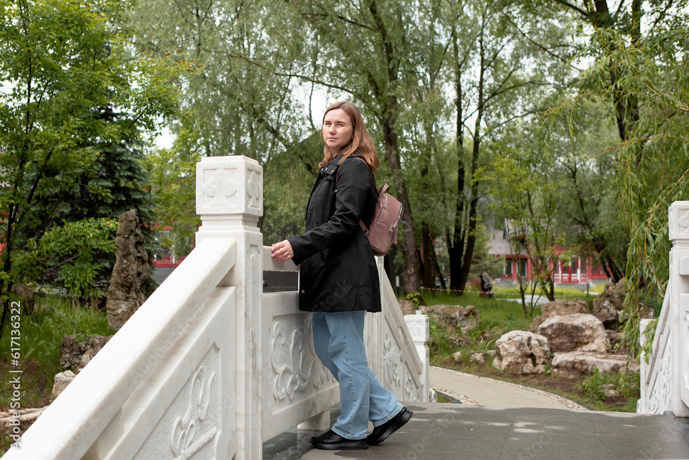 young woman walking in the park in the summer in rainy weather young woman walking in the park in the summer in rainy weather
