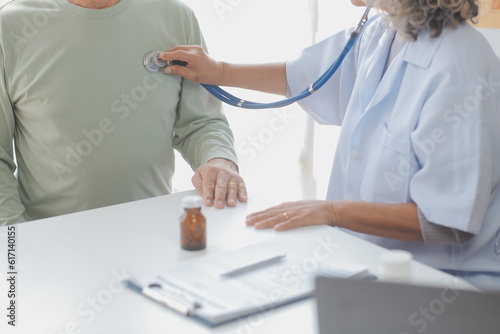 Mature Asian male doctor talking with his patient, explaining the procedure to old lady. © ARMMY PICCA
