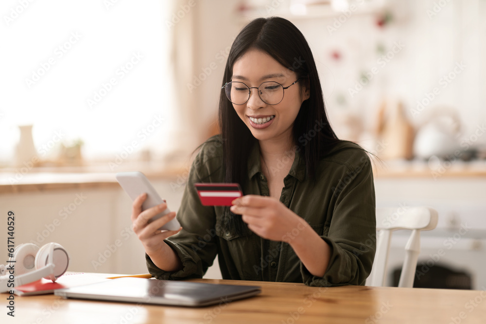 Positive asian woman freelancer banking or shopping from home Positive asian woman freelancer banking or shopping from home