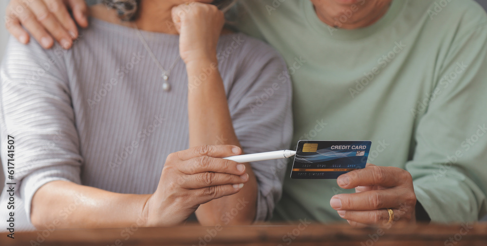 Close up mature man holding plastic credit card, senior couple family paying online, using laptop, satisfied older customers making secure internet payment, shopping, browsing banking service