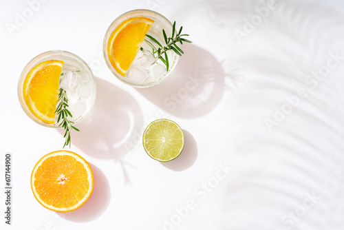Foto Summer cocktails with citrus fruits orange lemon lime mint and rosemary on a white background