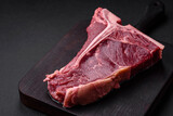 Raw juicy beef t-bone steak with salt, spices and herbs
