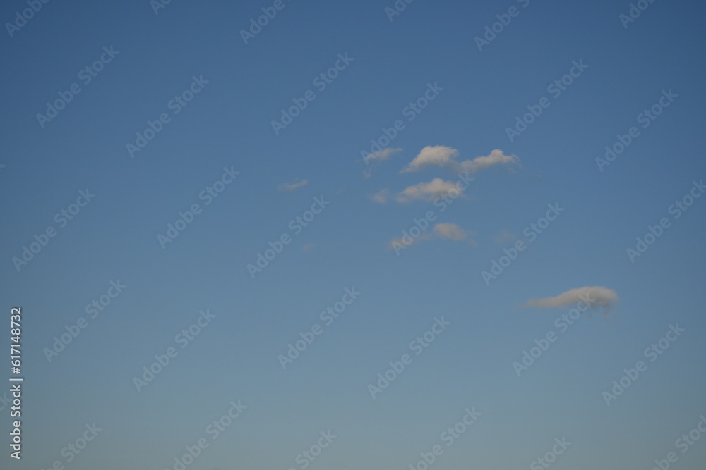 Fototapeta premium Clear blue skies with fluffy white clouds, white cloud against a blue summer sky, summer lonely clouds against a soft blue summer sky