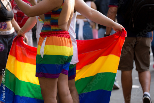 Jovens vestidos com com roupas com as cores da bandeira que simboliza o orgulho gay. 27ª edição, da Parada do Orgulho LGBT+ de São Paulo, Brasil.  photo