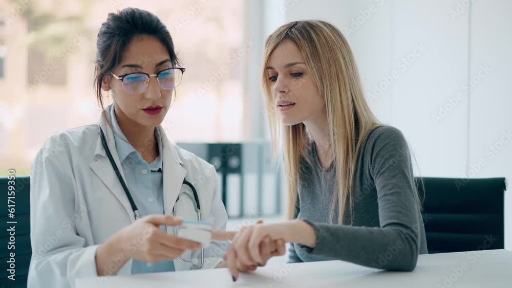 Video of beautiful female doctor measuring heart and blood pressure while taking care to young patient in the medical consultation Video of beautiful female doctor measuring heart and blood pressure while taking care to young patient in the medical consultation