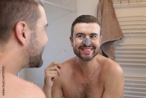 Man using a nose strip to remove black dots