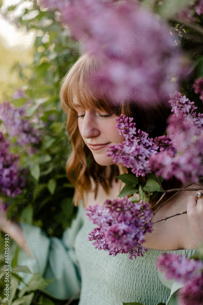Young woman standing in the purple lilac bush. Young woman standing in the purple lilac bush.