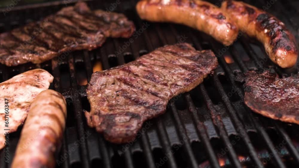 Searing and flipping ribeye steaks on grill. Ribs on flaming grill barbecued. barbecue meat on grill. Meat cooking on barbecue grill for summer outdoor party
