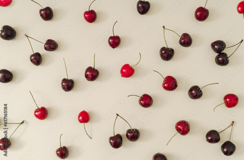 Fruit pattern made of red cherries on pastel cream background. Minimal cherry fruit layout. Creative nature summer pattern concept. Flat lay summer food idea. Fruit pattern made of red cherries on pastel cream background. Minimal cherry fruit layout. Creative nature summer pattern concept. Flat lay summer food idea.