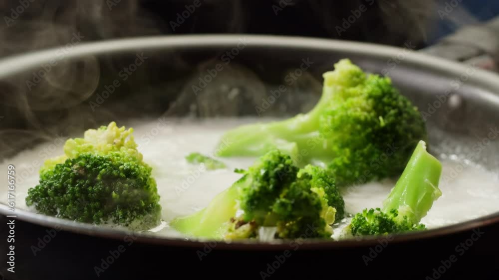 Broccoli, cauliflowers cooking in a creamy sauce in pan, close-up green vegetables boiling in a pan. Healthy boiled vegetables for cream vegan soup. Broccoli, cauliflowers cooking in a creamy sauce in pan, close-up green vegetables boiling in a pan. Healthy boiled vegetables for cream vegan soup.