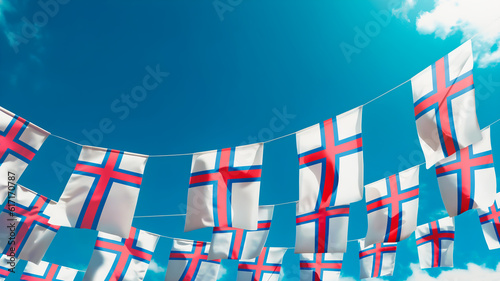 Flag of Faroe Islands against the sky, flags hanging vertically photo