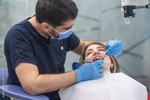 Dental care in modern clinic focused orthodontist looking at teeth of female patient using professional tools skilled specialist preparing woman for bite correction