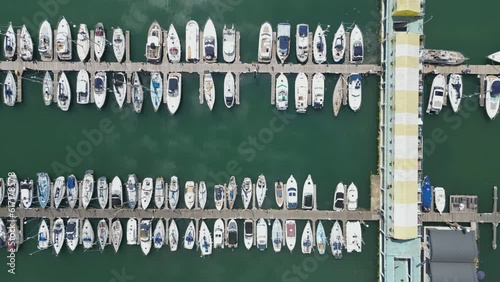 Panning aerial shot of boats docked on a harbour.