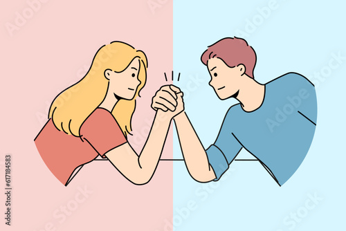 Arm wrestling between couple of man and woman for concept of fighting for leadership in family. Guy with girl compete who is stronger competing for position in company or leadership in team