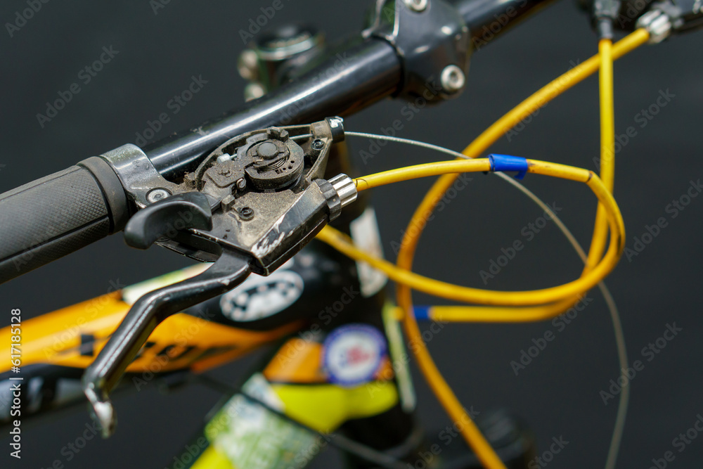 Handlebars of a mountain bike close-up on a black background in the studio. Bicycle repair, replacement of brake handles and gearshift systems. Handlebars of a mountain bike close-up on a black background in the studio. Bicycle repair, replacement of brake handles and gearshift systems.