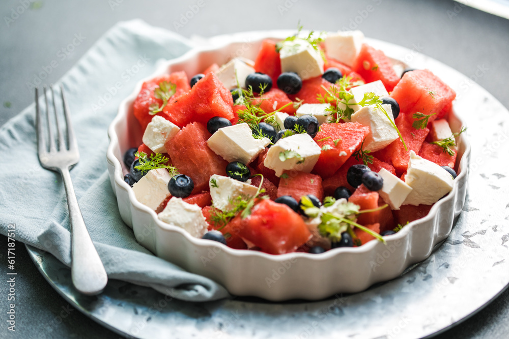 Summer salad with watermelon, feta cheese and mint on a gray background. Vegan, European food. Summer salad with watermelon, feta cheese and mint on a gray background. Vegan, European food.